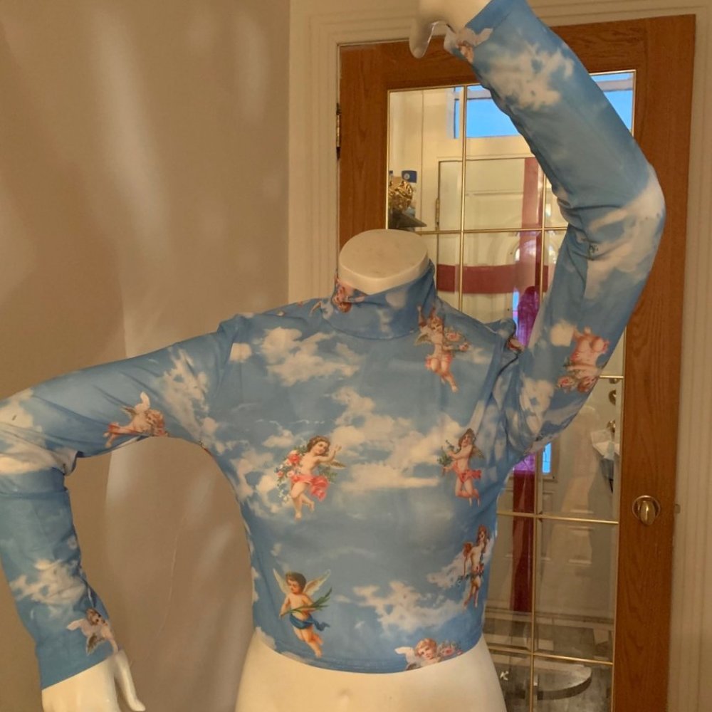 Chandail transparent bleu pâle extensible avec motif anges. (NEUF)